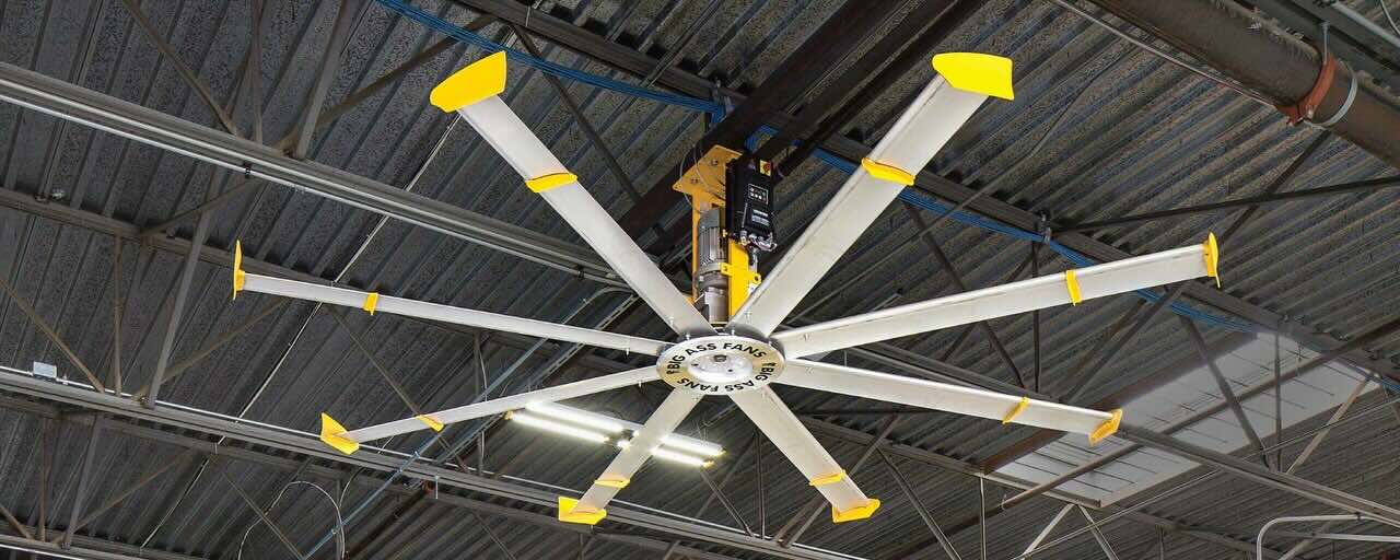 A large industrial fan by Big Ass Fans is expertly installed in a large warehouse facility to provide energy-efficient and effective air circulation.