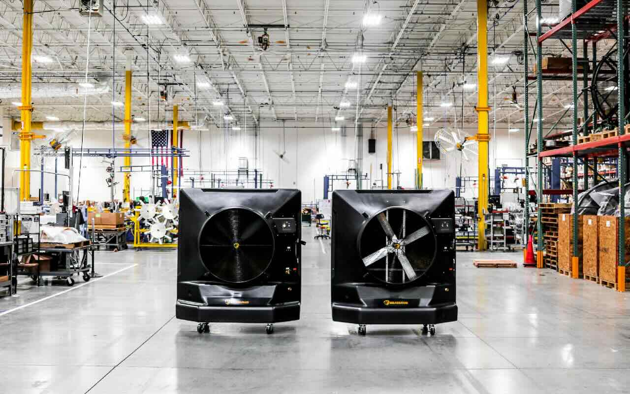 Two modern evaporative coolers by Big Ass Fans are shown in a large warehouse.