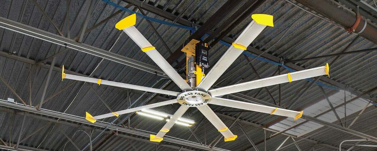 The inside view of a warehouse with a large industrial fan by Big Ass Fans is securely installed and positioned for optimal air circulation.