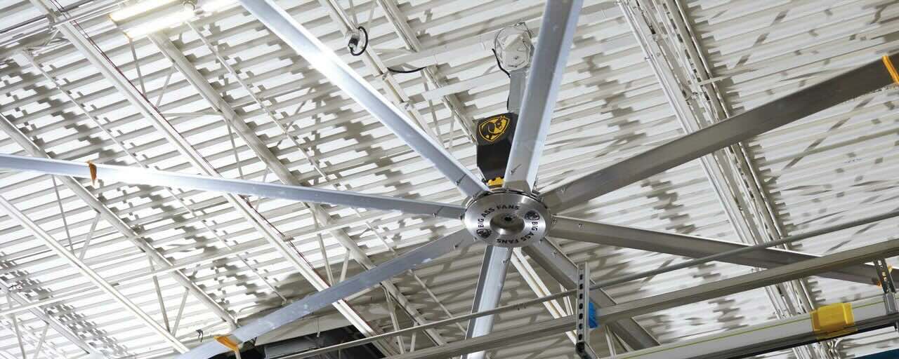 The inside view of an industrial building, looking toward the metal ceiling with the large HVLS fan by Big Ass Fans.