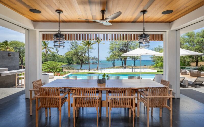 The view of an outside patio area next to a pool, with an inviting covered gazebo featuring a ceiling fan by Big Ass Fans expertly installed to provide maximum efficiency and comfort.